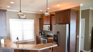 A kitchen with a central island, stainless steel appliances, and wooden cabinets.