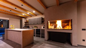 A modern kitchen with a central island, built-in oven, and a large fireplace. - Gorgeous home in Biograd na moru with sauna (Biograd na moru)