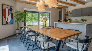 A modern kitchen with a wooden table, chairs, and pendant lights. - Gorgeous home in Biograd na moru with sauna (Biograd na moru)