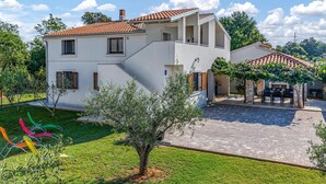 A two-story house with a tiled roof, a covered patio, and a small garden. - Gorgeous apartment in Medulin (Medulin)