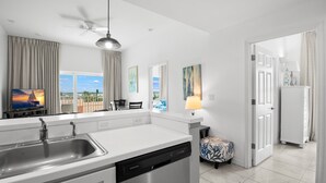 A modern kitchen with a dishwasher, a ceiling fan, and a view of the outdoors. - 🐾 Madeira Bay Resort I #1601 – Spacious, Pet-Friendly Escape by the Shore (Madeira Beach)