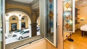 A hotel room with a large window, a view of parked cars, and a decorative glass partition. - GuestHost - ★ Apt in the very center! 500 meters from Porta Nuova ★ (Torino)