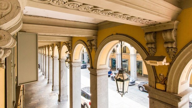 An interior corridor with classical arches and columns, leading to an outdoor street view. - GuestHost - ★ Apt in the very center! 500 meters from Porta Nuova ★ (Torino)