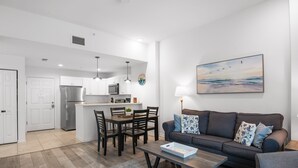 A modern apartment with a kitchen, dining area, and living room. - 🏝️ Madeira Bay Resort I #1403 – Cozy, Kid-Friendly (Madeira Beach)