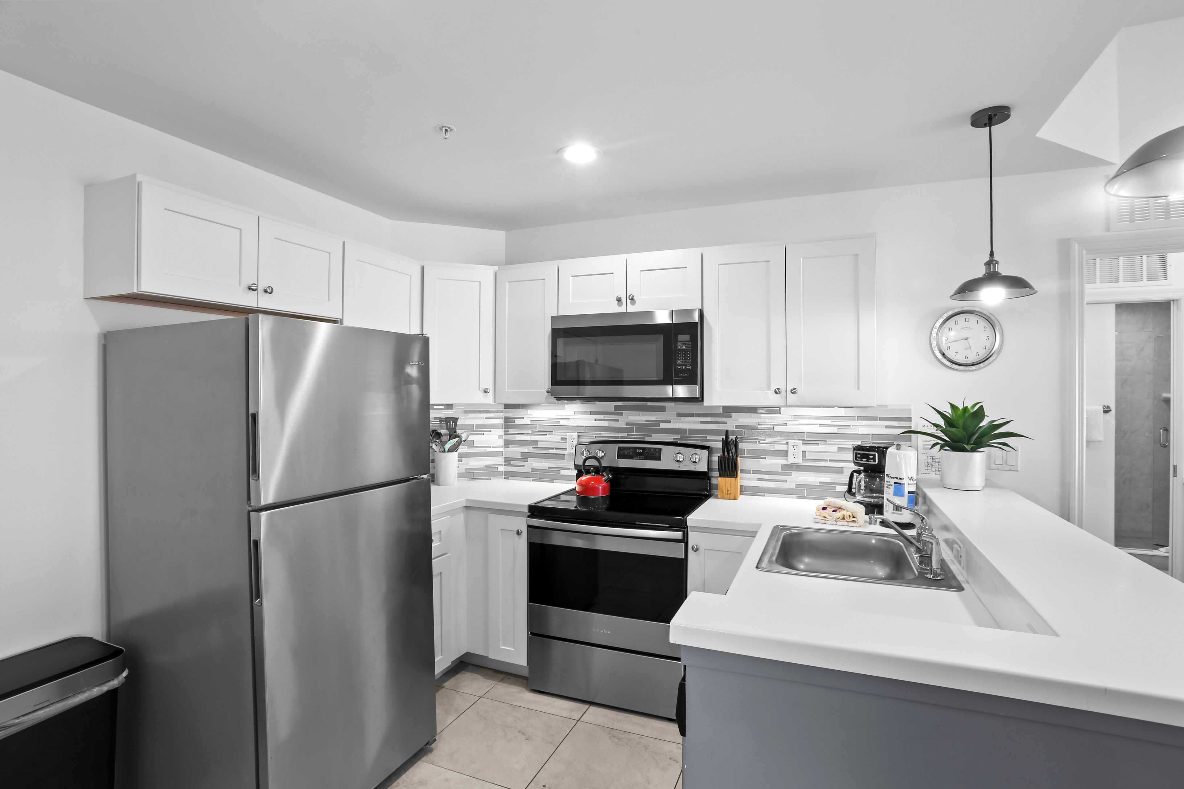 A modern kitchen with stainless steel appliances, a microwave, oven, and a sink.