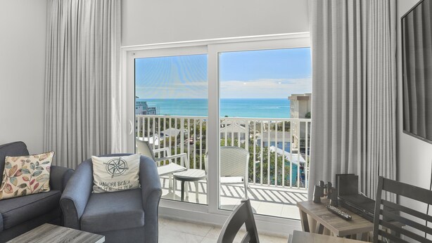 A balcony with a view of the ocean, a sofa, a table, and a chair. - 🐾 Madeira Bay Resort I #1608 – Pet-Friendly, Professionally Sanitized & Steps from the Shore (Madeira Beach)