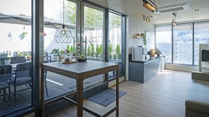 Una cocina moderna con comedor, ventanas amplias y vistas a la ciudad.
