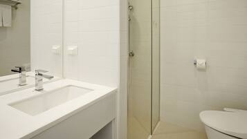 Une salle de bain moderne avec un lavabo blanc, un miroir et des toilettes.