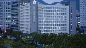 Un moderno edificio de hotel con varios pisos, amplias ventanas y un letrero llamativo.