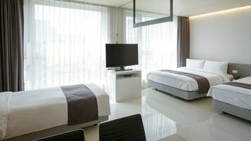 A hotel room with two beds, a TV, a desk, and a chair.