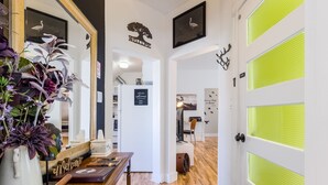 Un interior moderno con un mostrador de recepción de madera, un espejo grande y un cartel de bienvenida.