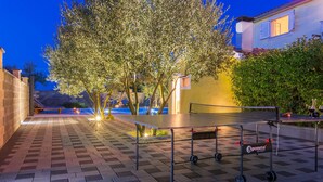 An outdoor ping pong table with a cart, surrounded by trees and a paved area. - Awesome apartment in Biograd na moru (Biograd na moru)