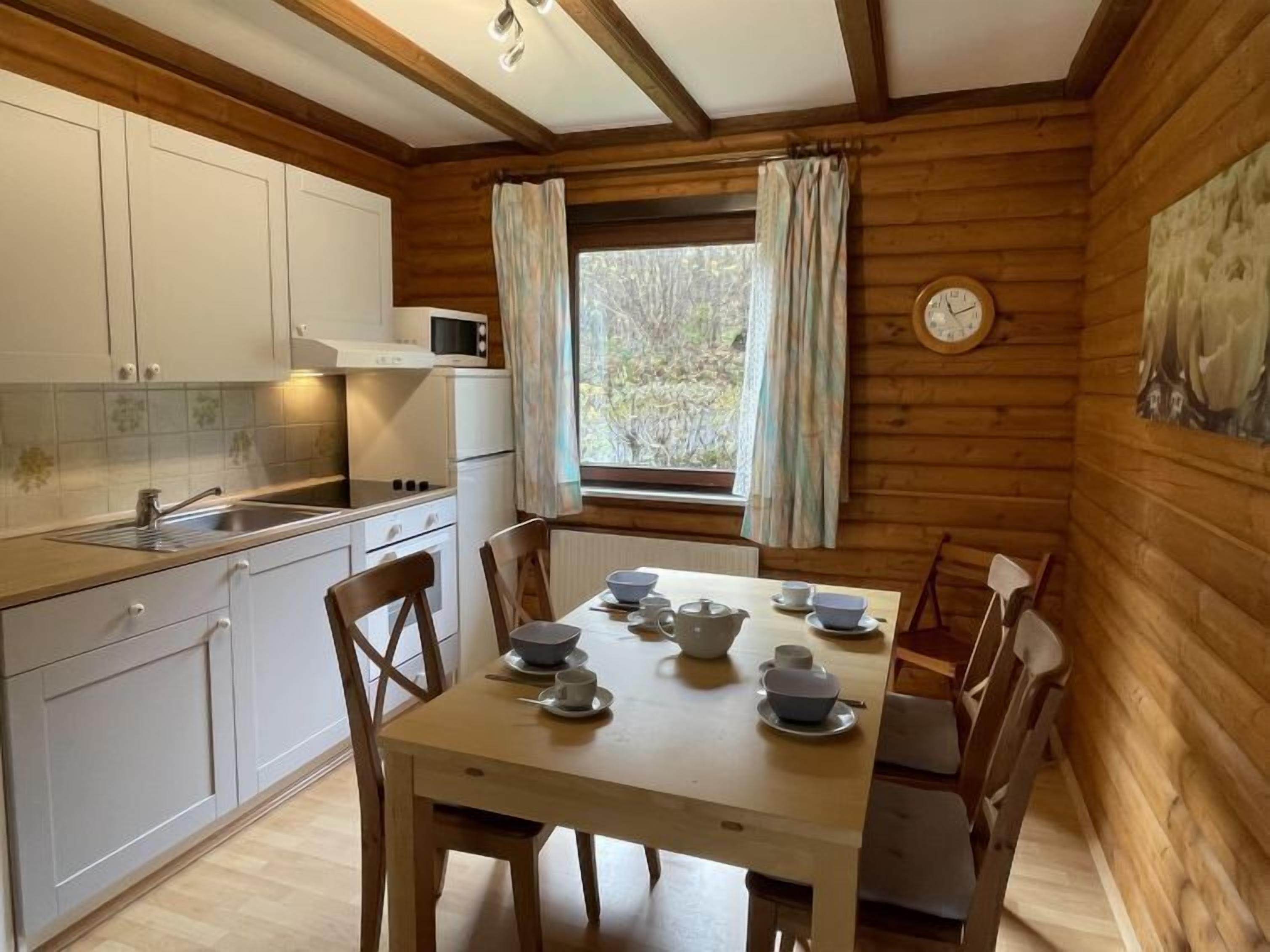 Ein Holzblockhaus-Interieur mit Küche und Essbereich.