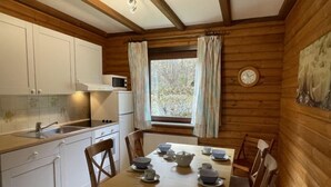 A wooden cabin interior with a kitchen and dining area.