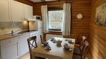 Ein Holzblockhaus-Interieur mit Küche und Essbereich.