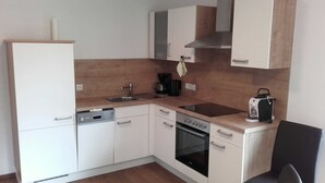 A compact kitchen with a dishwasher, oven, and a coffee maker.