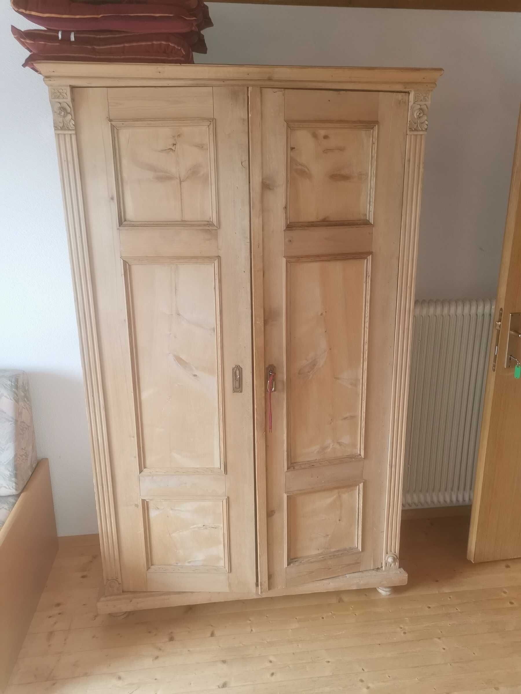Une armoire en bois avec une poignée et un trou de serrure.