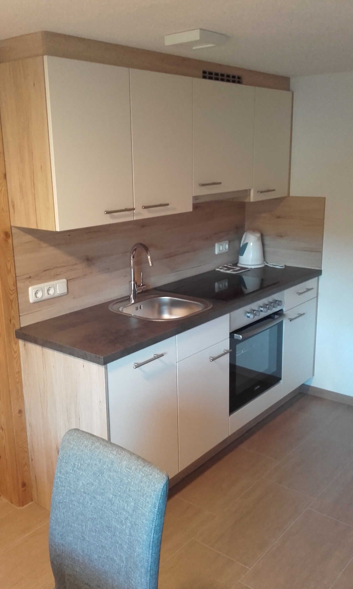 A kitchen with a sink, stove, and cabinets.