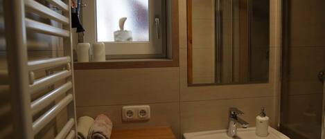 Een haardroger, handdoeken, zeep, toiletpapier