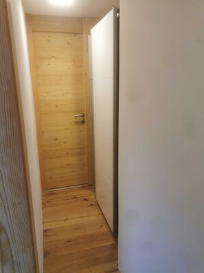 A narrow hallway with a wooden door and a white wall. - Ferienwohnung 8 - Gästehaus Obererlacher (Obertilliach)