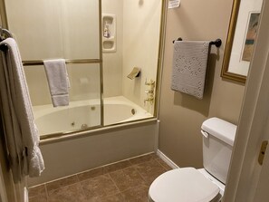 A bathroom with a bathtub, toilet, and a towel rack.