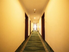 Un pasillo de hotel con pisos alfombrados y puertas a ambos lados.
