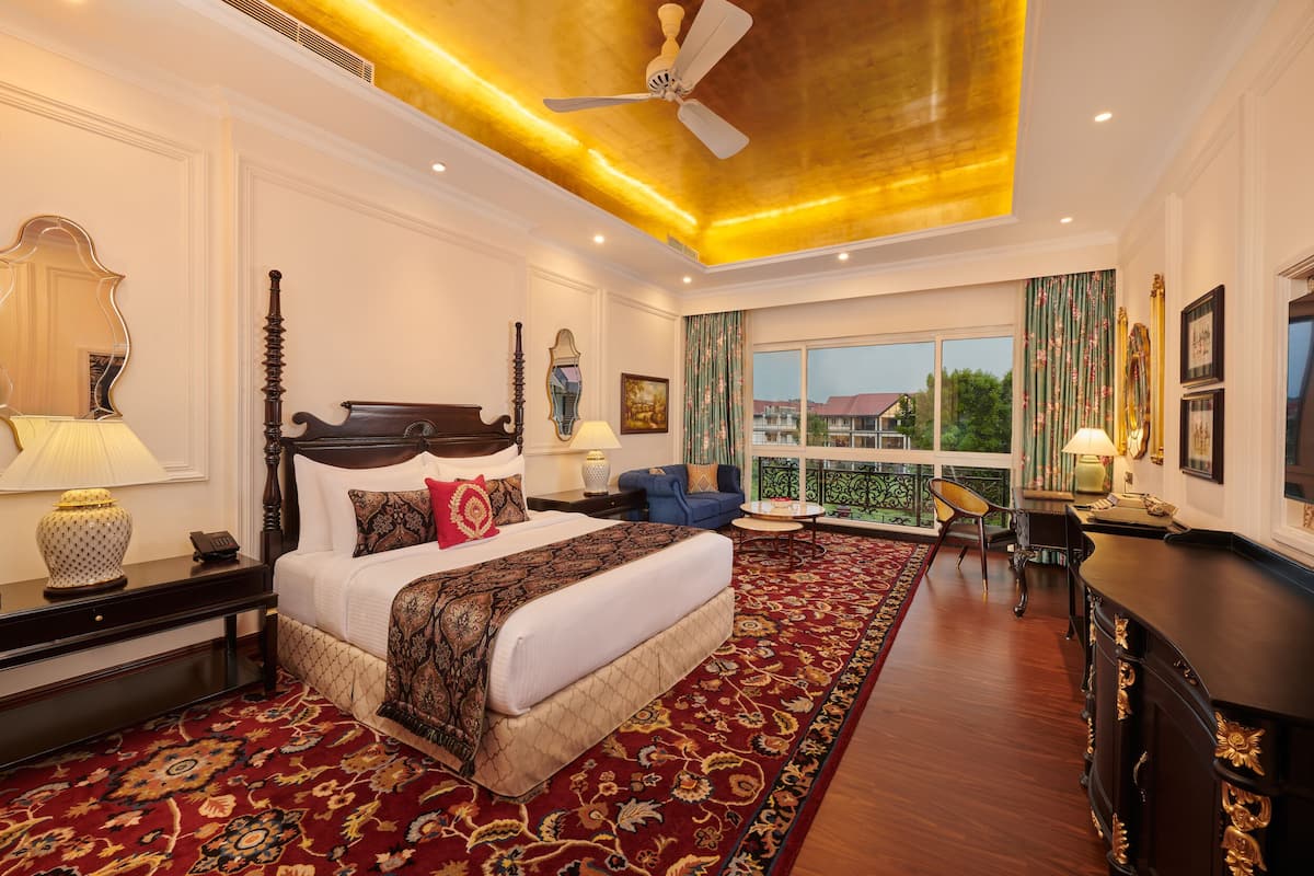 A spacious bedroom with a large bed, a ceiling fan, and a view of the outside.