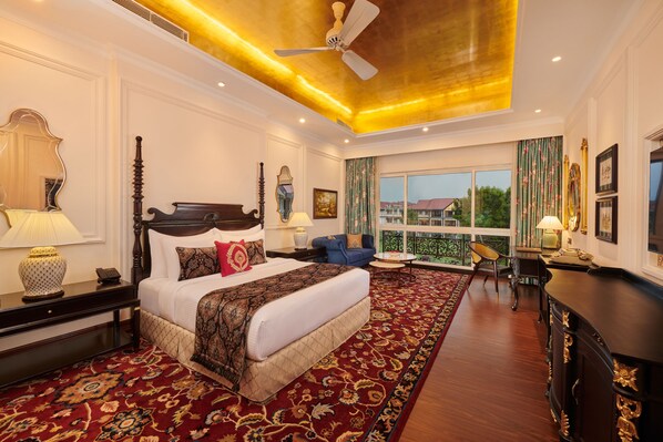 A spacious bedroom with a large bed, a ceiling fan, and a view of the outside.