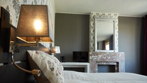 Une chambre d’hôtel équipée d’un lit, d’une télévision, d’un bureau et d’une cheminée.