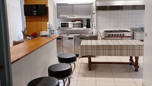 Une cuisine moderne avec un plan de travail en bois, des tabourets de bar, une table à manger et une cuisinière.