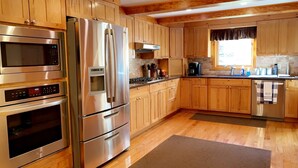 Una cocina moderna con electrodomésticos de acero inoxidable, armarios de madera y un amplio ventanal.