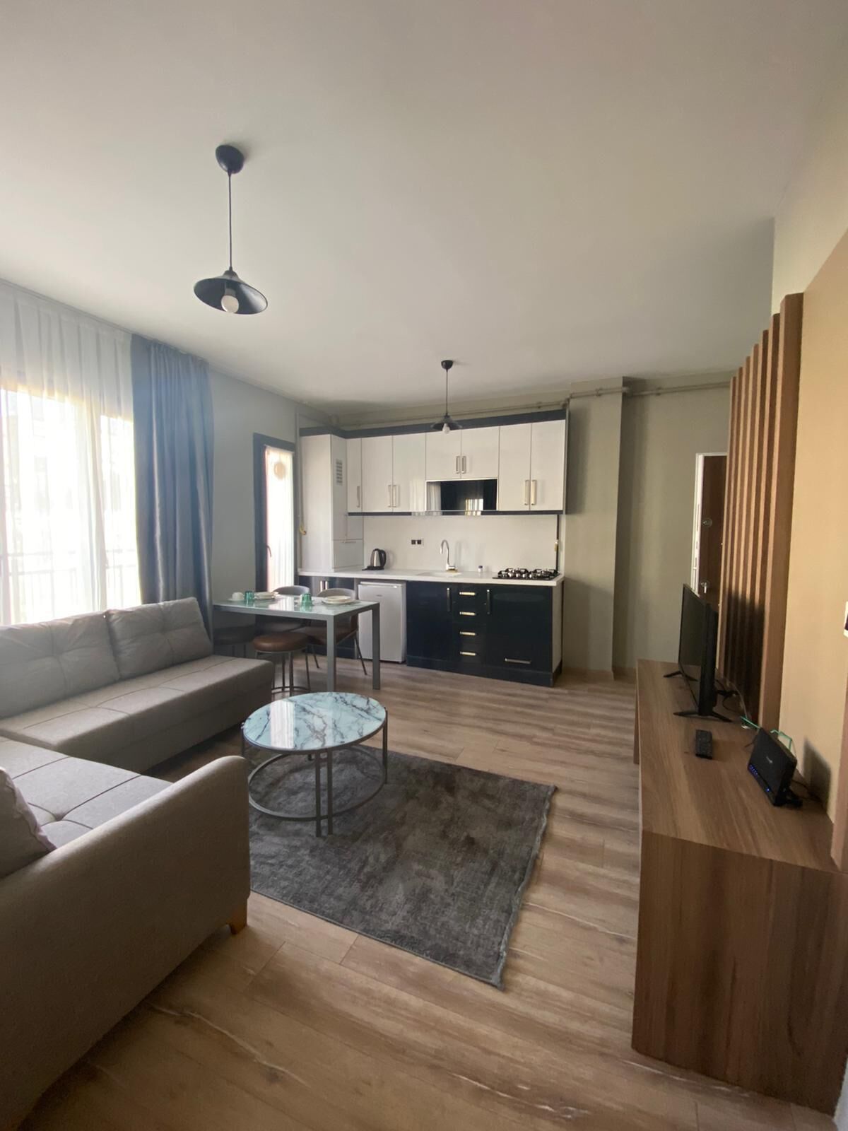 Uma sala de estar moderna com um sofá, uma mesa de centro e um rack para TV.