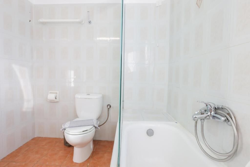 A bathroom with a toilet, a glass shower enclosure, and a bathtub.