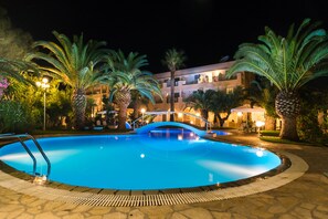 Una piscina al aire libre de temporada, sombrillas