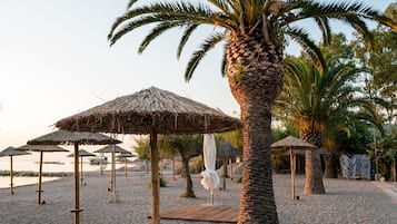 Aan het strand, ligstoelen aan het strand, parasols, een strandbar