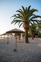 Na praia, espreguiçadeiras, guarda-sóis, bar na praia 