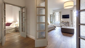 Una habitación con cama, sofá, mesa y televisión.