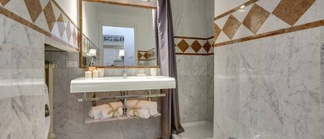 Un baño moderno con lavamanos, espejo y bañera blancos.