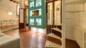 A hallway with a green wall, a white radiator, and a white shelf unit. - Mamo Florence - Tegolaio Apartment (Florence)