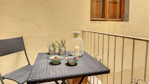 A small outdoor table with two bowls of fruit, a candle, and small plants. - Mamo Florence - Tegolaio Apartment (Florence)
