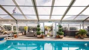 An indoor swimming pool with a glass ceiling, surrounded by lounge chairs and potted plants. - St Anne's House, Sea Views, 7 Bedrooms - Sleeps 30 (Plymouth)