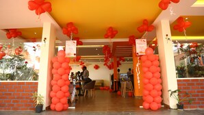 A hotel entrance decorated with red balloons and a brick facade. - Karma Palace (Bangalore)