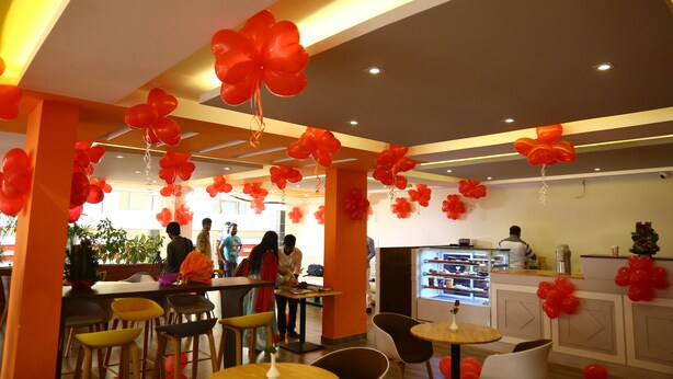 A restaurant with red balloons, bar stools, and a counter. - Karma Palace (Bangalore)