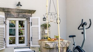 Una petita zona exterior amb taula de pedra, dues cadires i una bicicleta.