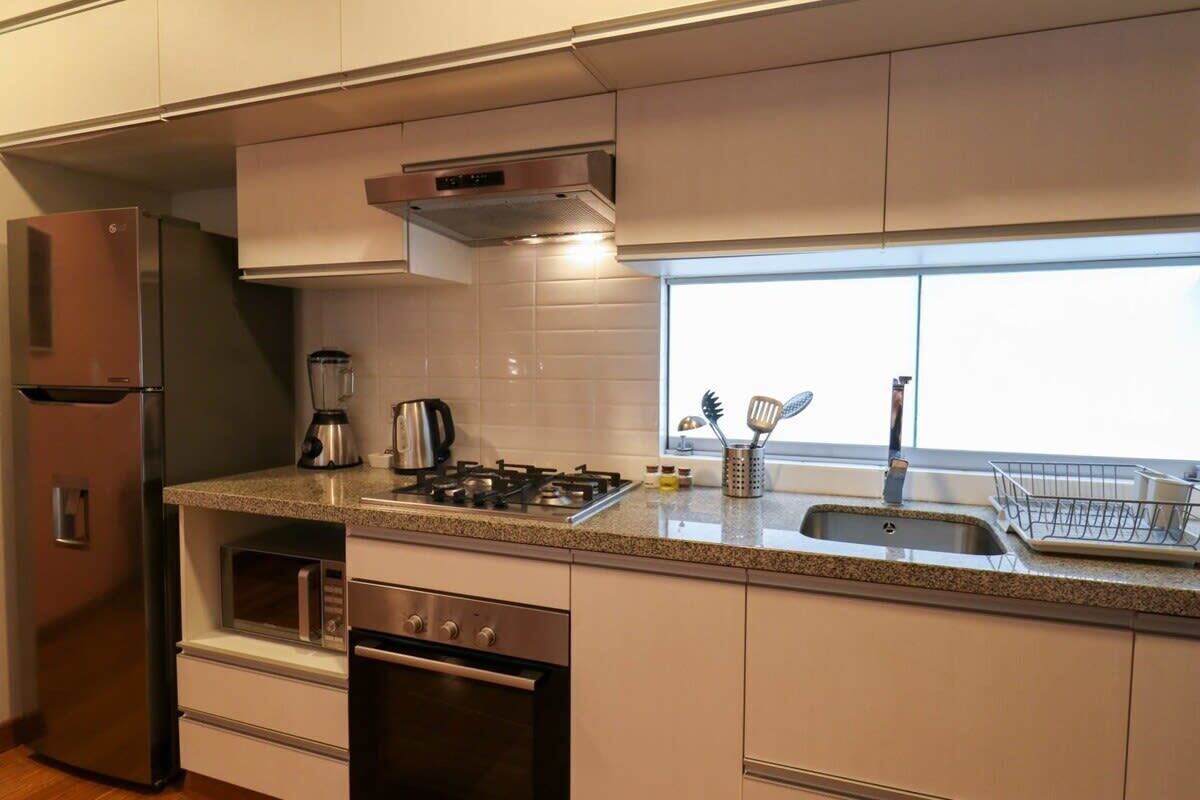 A modern kitchen with stainless steel appliances, a gas stove, and a built-in oven.