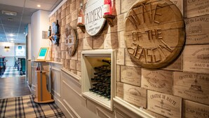 A wine cellar with wooden walls, wine racks, and bottles. - Claymore Hotel (Arrochar)
