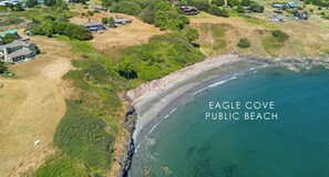Luchtbeeld van Eagle Cove openbaar strand met omliggende woonwijken en een heldere lucht.
