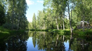 Eine friedliche Seebucht mit einer Holzhütte und einem Steg, der ins Wasser führt.