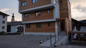 Un bâtiment moderne à plusieurs étages, doté d’une façade en bois, d’un escalier apparent et d’un petit balcon.