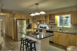 Enjoy cooking in this well-equipped kitchen with a central island, bar stools, and ample counter space.